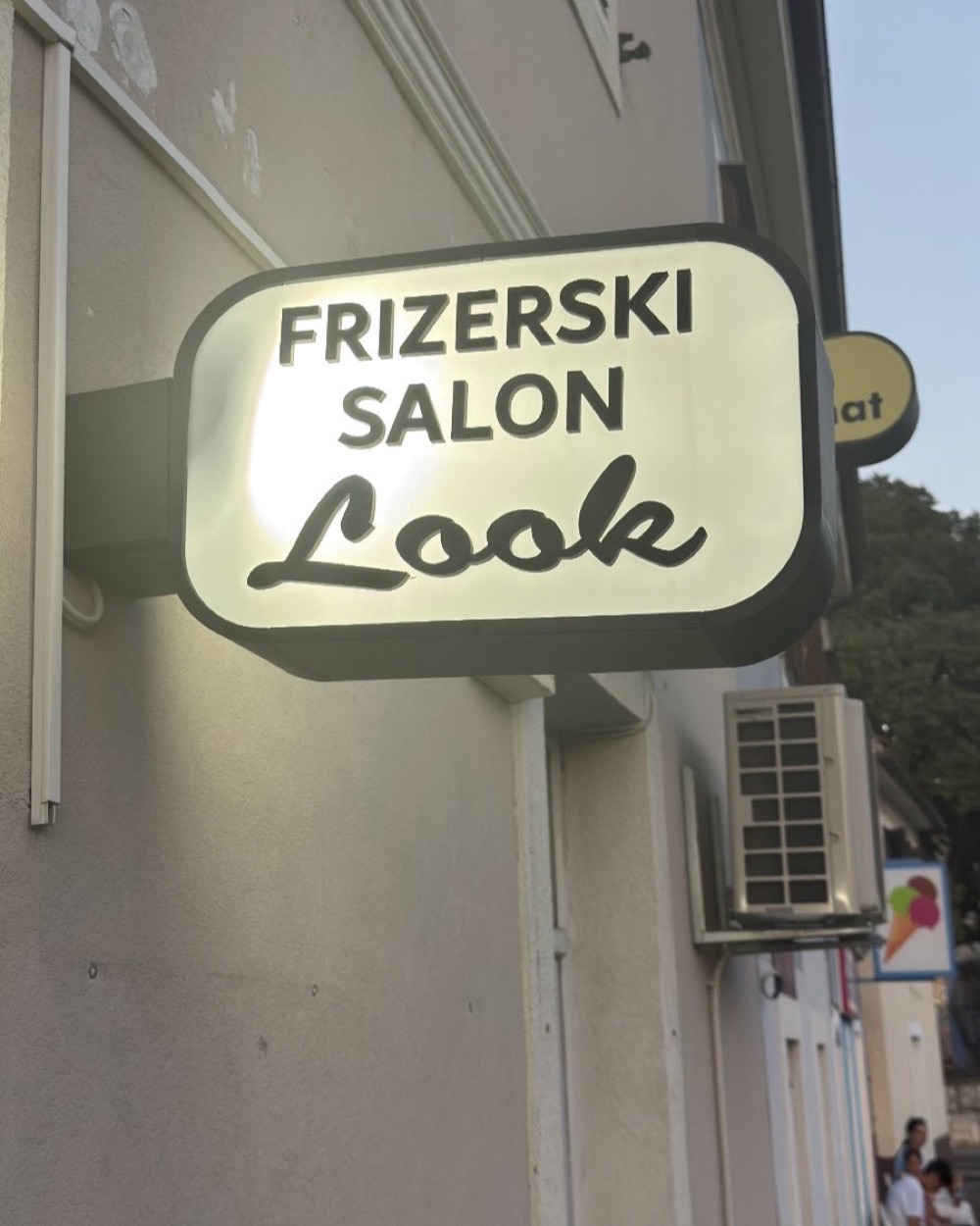 Osvijetljeni natpis „Frizerski salon Look" nad ulazom u salon na Trsatu